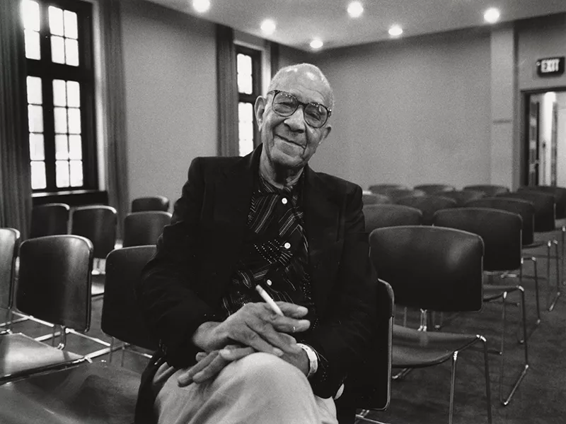 Nathaniel Barnes sitting in a chair, with a cigarette in hand.