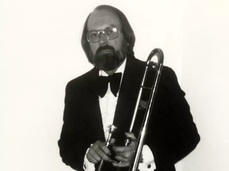 Leonard Carnagey dressed in a tuxedo holding a trombone.