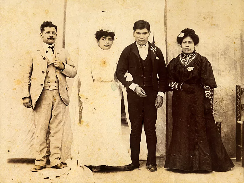 A wedding portrait with the bride and groom and two additional persons